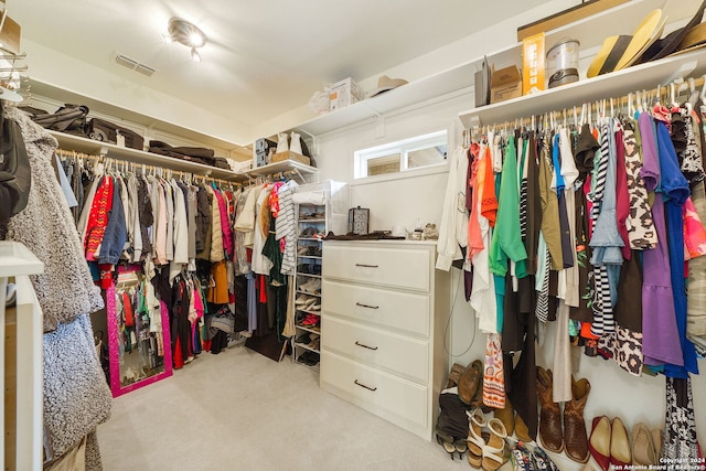 walk in closet with light carpet