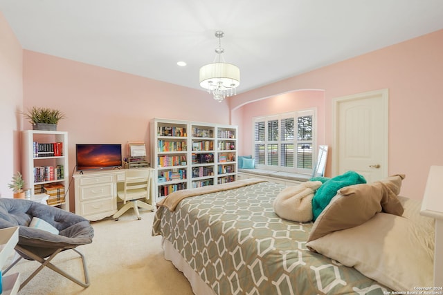 carpeted bedroom with a notable chandelier