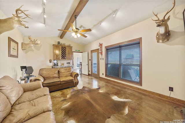 living room featuring ceiling fan, rail lighting, vaulted ceiling with beams, bar area, and concrete floors