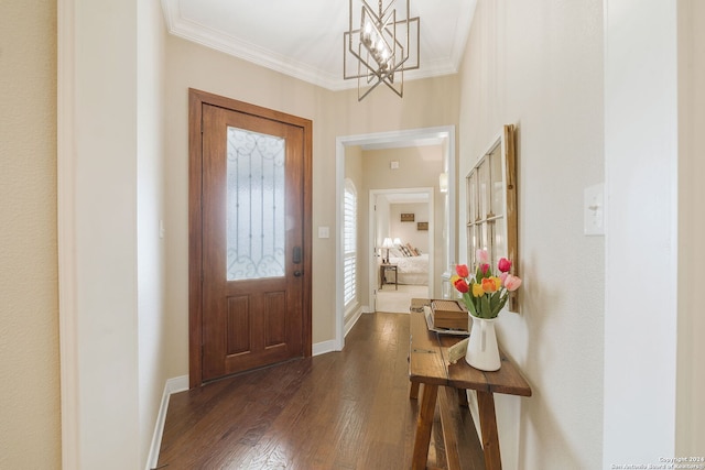 foyer with dark hardwood / wood-style floors, ornamental molding, and a notable chandelier