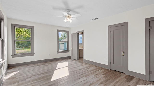 603 E Cedar St, Seguin, TX 78155 - unfurnished bedroom with light wood finished floors, baseboards, and ensuite bathroom