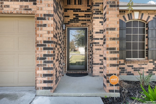 doorway to property with a garage