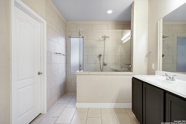 bathroom featuring tile patterned flooring, vanity, and tiled shower