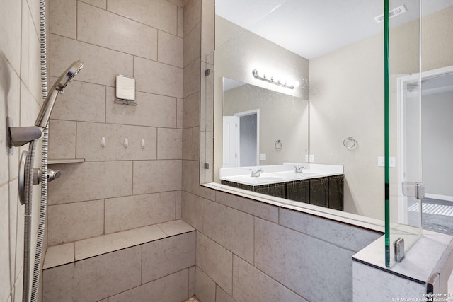 bathroom featuring vanity and tiled shower