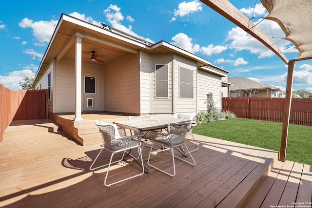 wooden deck featuring ceiling fan and a yard