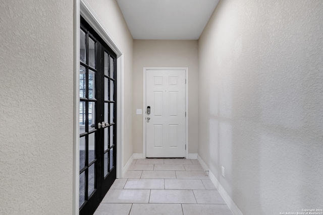 doorway with french doors and light tile patterned floors