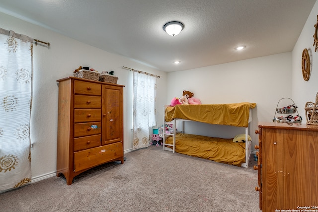 bedroom with light carpet and a textured ceiling