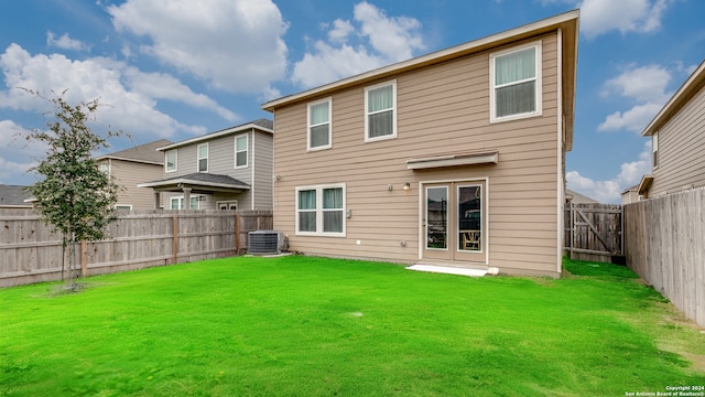 rear view of property featuring a yard and cooling unit