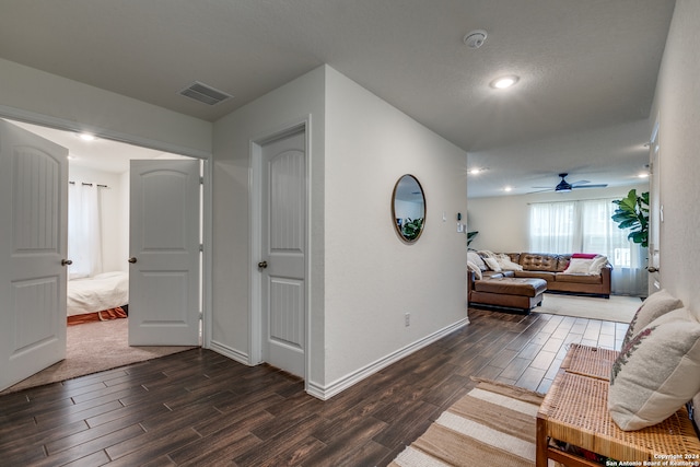 living room with ceiling fan, dark wood-type flooring, and a textured ceiling