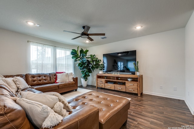 living room with a textured ceiling, ceiling fan, and dark hardwood / wood-style floors