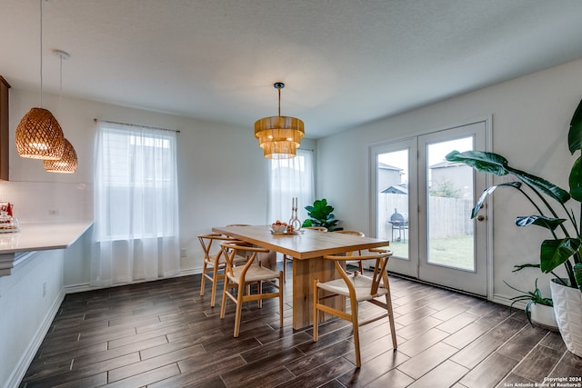 dining space featuring a textured ceiling, dark hardwood / wood-style floors, and a wealth of natural light