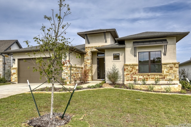 prairie-style home featuring a front yard and a garage