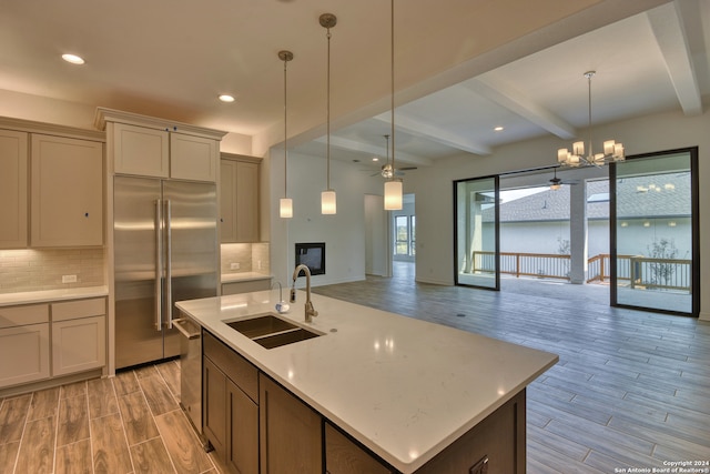 kitchen featuring beamed ceiling, light wood-type flooring, stainless steel appliances, and sink