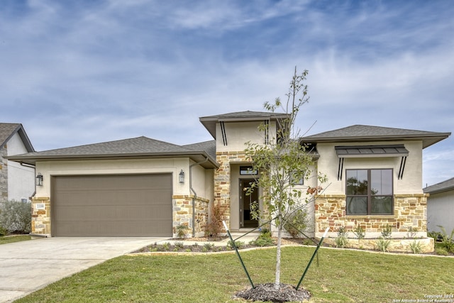 prairie-style house featuring a front lawn and a garage