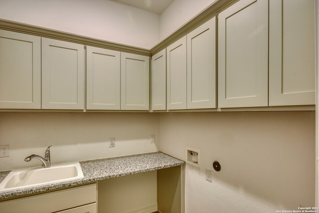 clothes washing area with sink, cabinets, and washer hookup