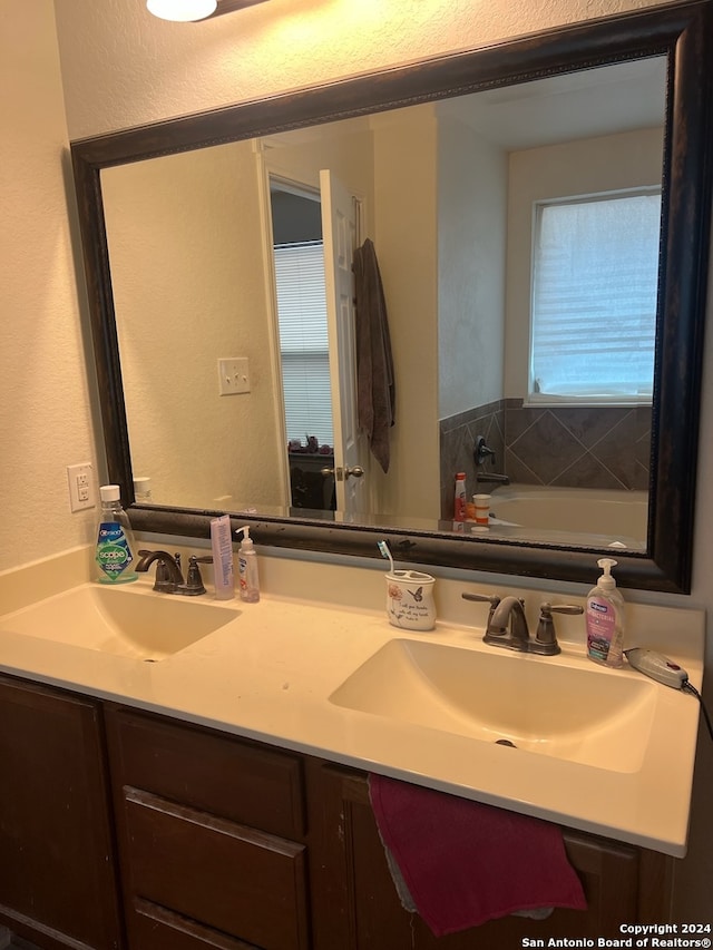 bathroom featuring a tub to relax in and vanity