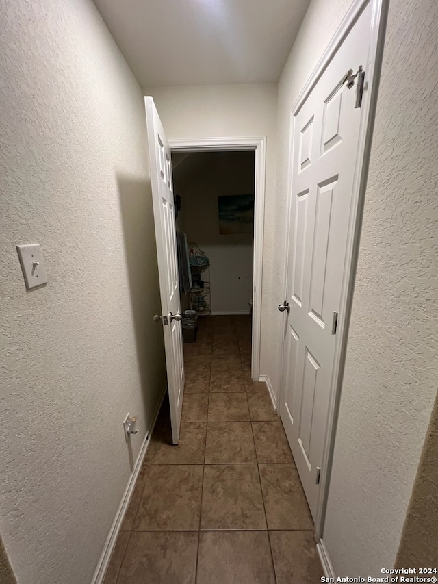 hallway featuring dark tile patterned flooring