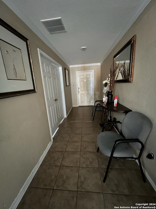 hall featuring dark tile patterned flooring and ornamental molding