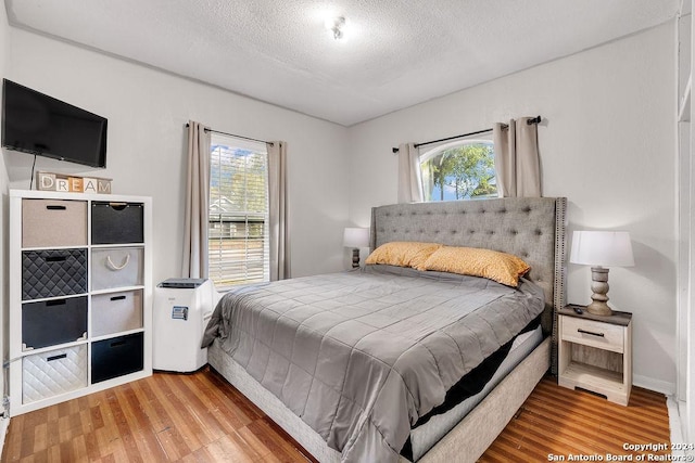 830 Canton, San Antonio, TX 78202 - bedroom with multiple windows, wood finished floors, a textured ceiling, and baseboards