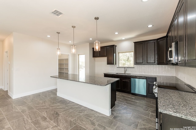 kitchen featuring sink, a kitchen island, dark stone countertops, and stainless steel appliances