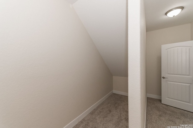 interior space featuring light carpet and vaulted ceiling