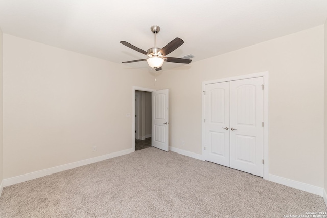 unfurnished bedroom featuring ceiling fan, light carpet, and a closet