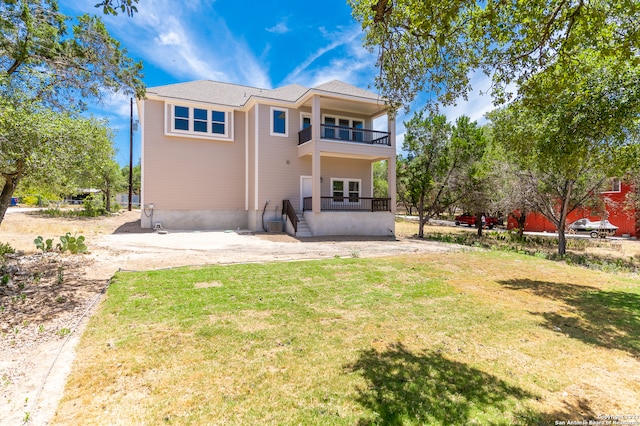 back of property featuring a yard and a balcony