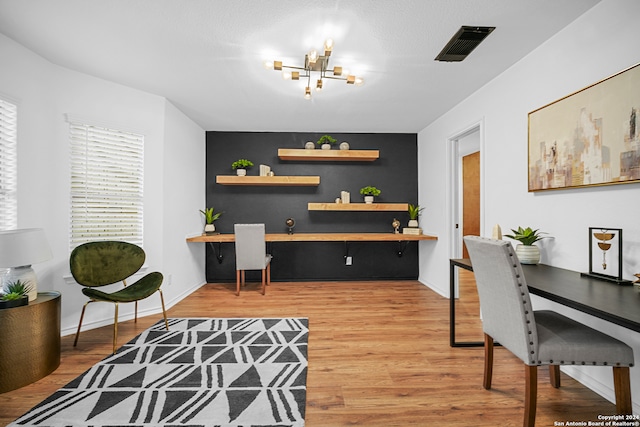 home office with hardwood / wood-style flooring and a notable chandelier