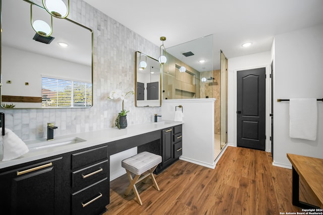 bathroom featuring a shower, hardwood / wood-style floors, and vanity