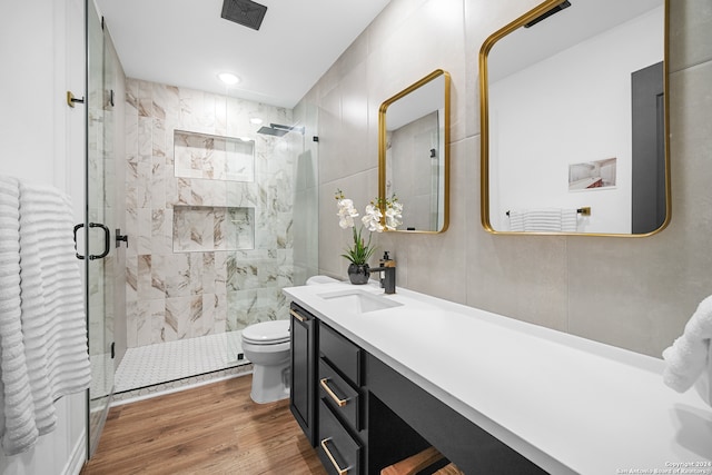 bathroom with wood-type flooring, vanity, toilet, and an enclosed shower