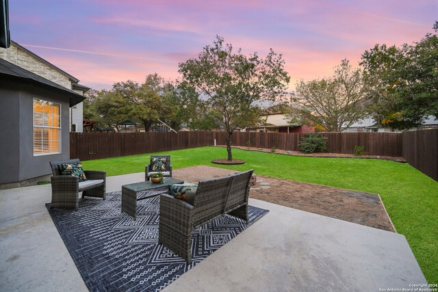 patio terrace at dusk featuring outdoor lounge area and a yard