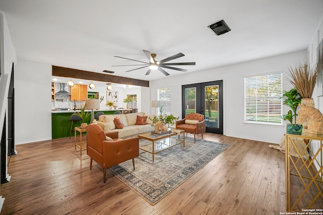 living room with hardwood / wood-style flooring, ceiling fan, and french doors