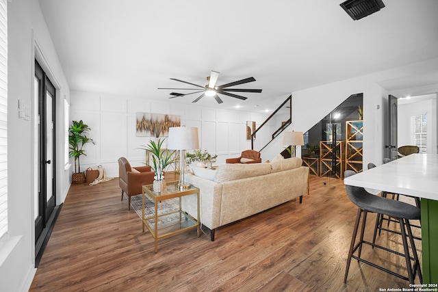 living room with dark hardwood / wood-style floors and ceiling fan