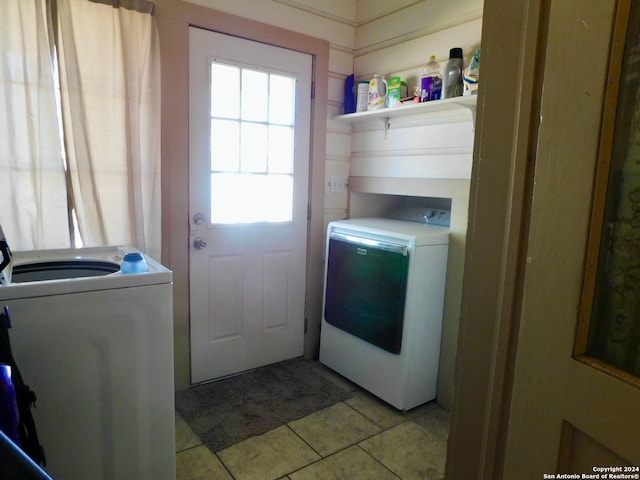 washroom with light tile patterned floors and washing machine and clothes dryer