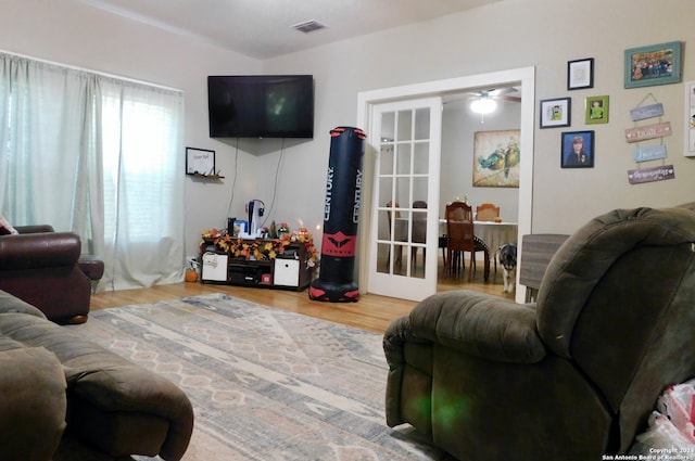 living room featuring hardwood / wood-style floors, french doors, and ceiling fan