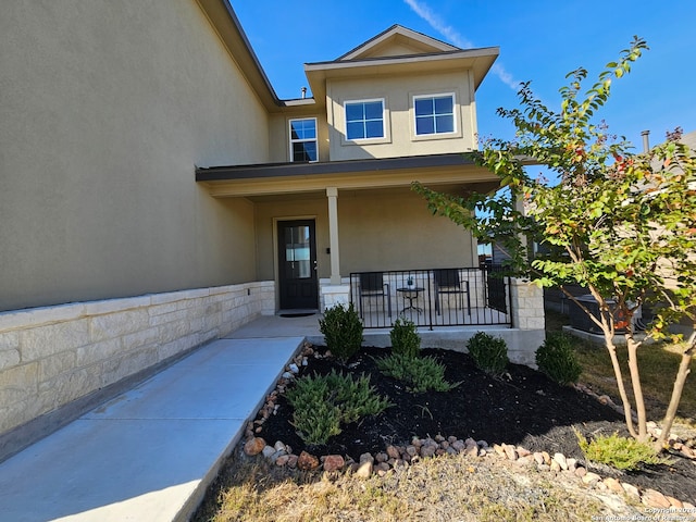 view of exterior entry with a porch