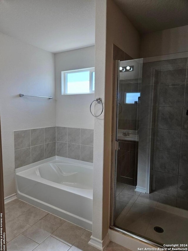 bathroom featuring tile patterned flooring, a textured ceiling, and independent shower and bath