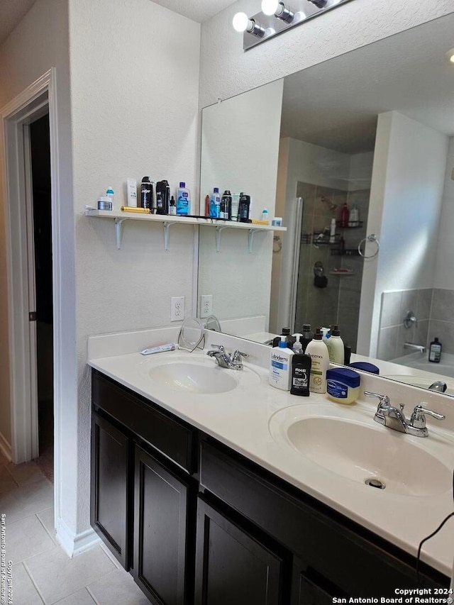 bathroom featuring tile patterned floors, vanity, and a shower with shower door