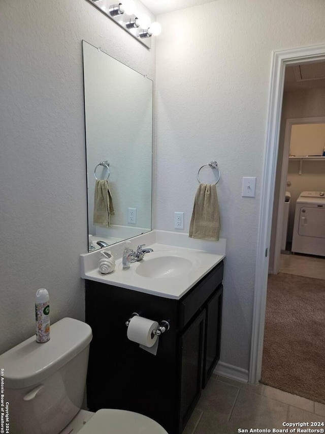 bathroom with tile patterned flooring, independent washer and dryer, vanity, and toilet