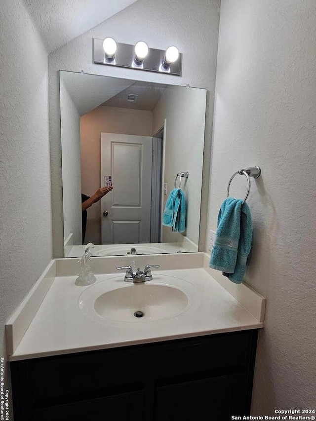 bathroom featuring vanity and vaulted ceiling