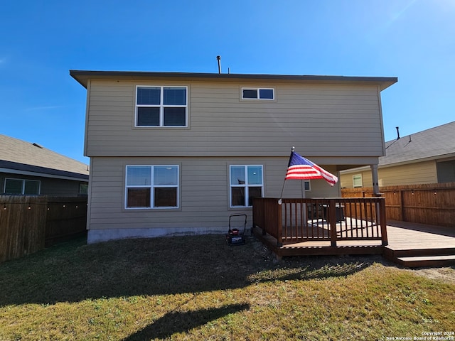 rear view of house with a yard and a wooden deck