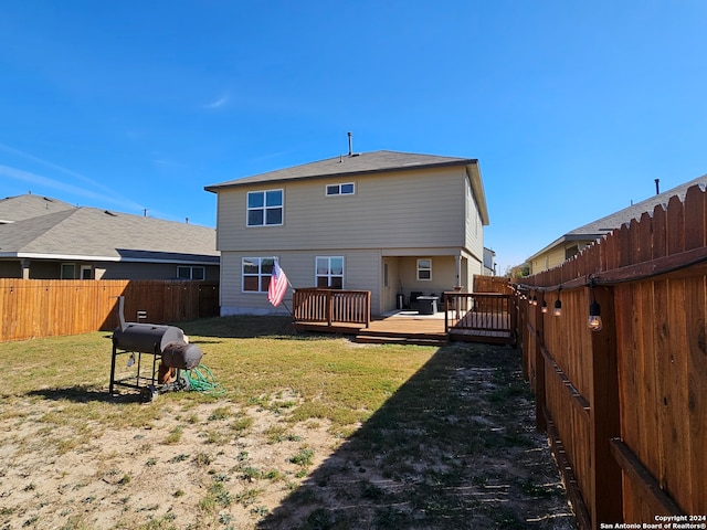 rear view of house featuring a yard and a deck