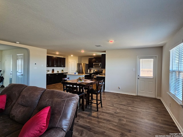 dining area with dark wood-type flooring and a textured ceiling