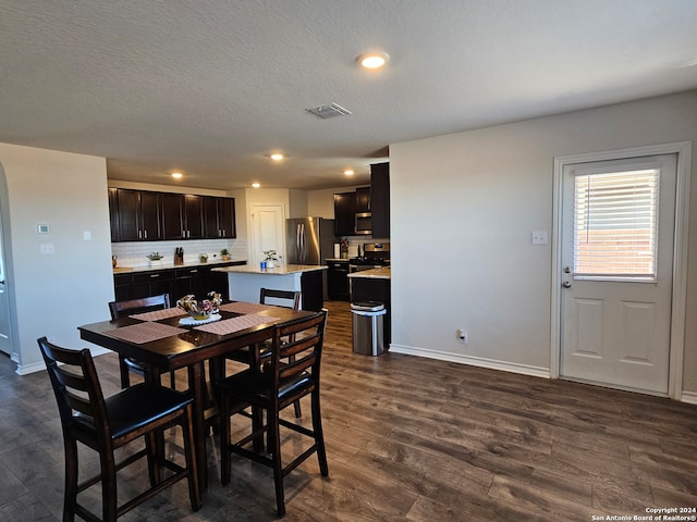 dining area featuring dark hardwood / wood-style floors and a textured ceiling