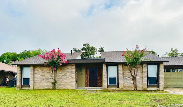 view of front of home with a garage and a front lawn