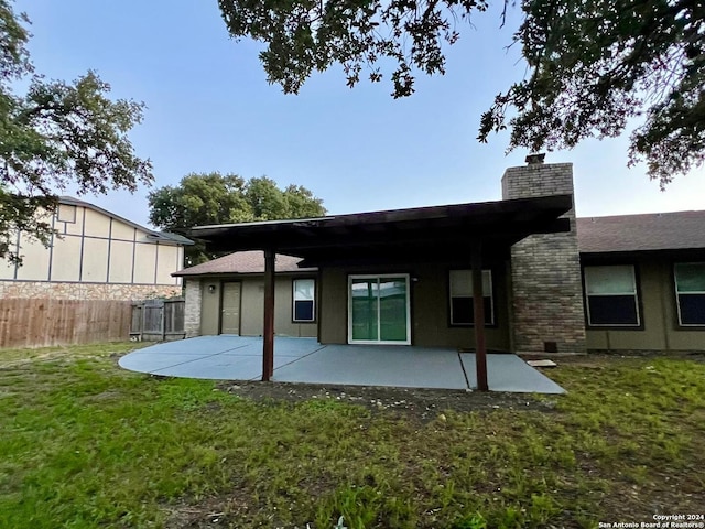 back of property featuring a lawn and a patio area