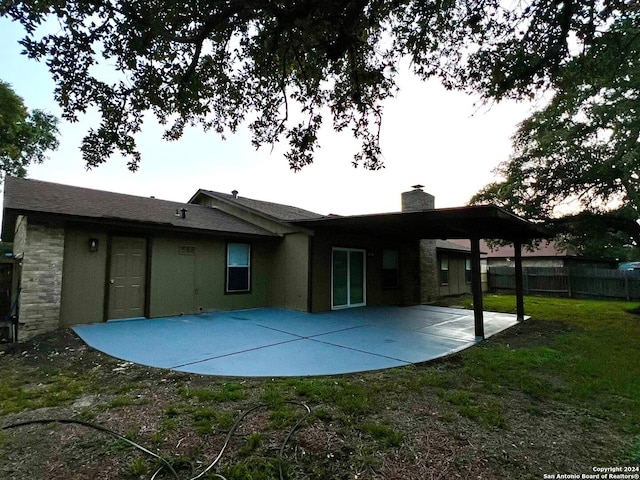 rear view of house featuring a lawn and a patio area