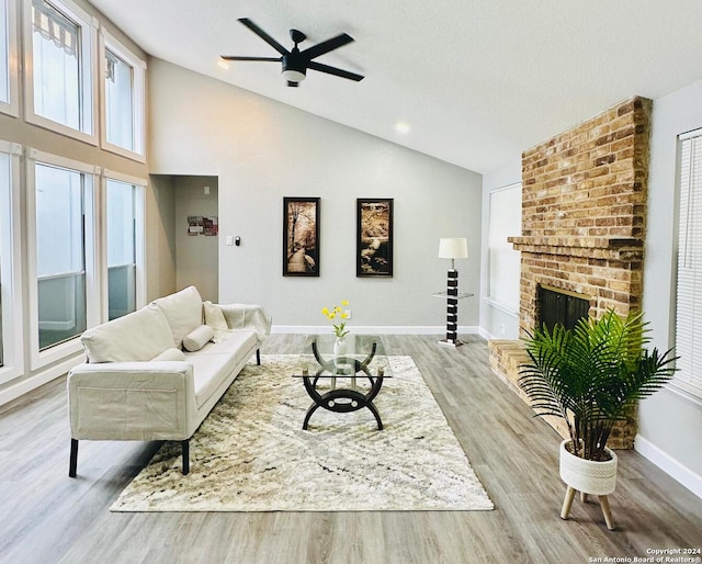 living room with a fireplace, light wood-type flooring, and ceiling fan