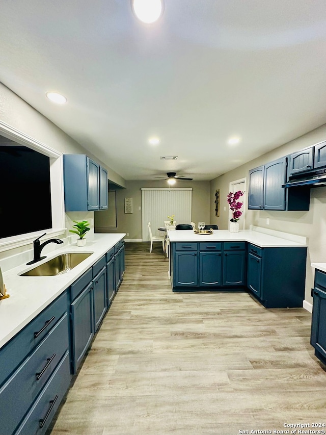 kitchen with light hardwood / wood-style floors, blue cabinets, ceiling fan, and sink