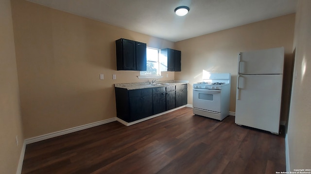 kitchen with dark hardwood / wood-style flooring, white appliances, and sink